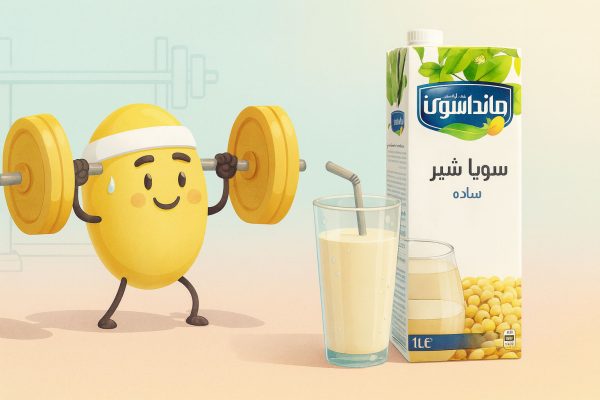 لوبیای سویا در حال لیفت هالتر کنار لیوان نوشیدنی سویا و بسته‌بندی سویا شیر ساده مانداسوی؛ حس انرژی و پروتئین گیاهی