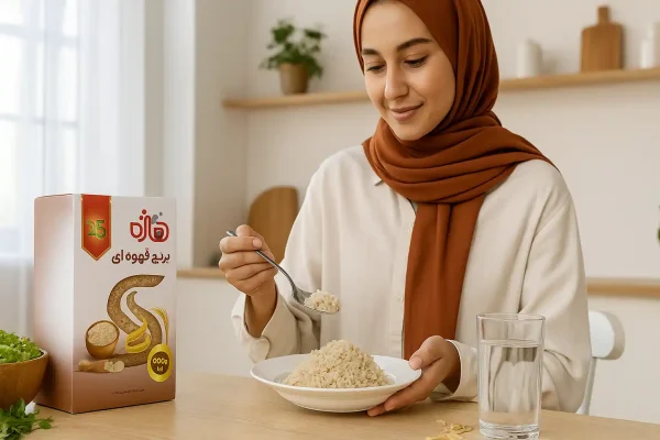 خانم جوان باحجاب در آشپزخانه روشن در حال سرو برنج قهوه‌ای پخته‌شده در ظرف سفید، کنار بسته برنج قهوه‌ای هاژه روی میز با نور طبیعی و فضای سالم و گرم خانگی