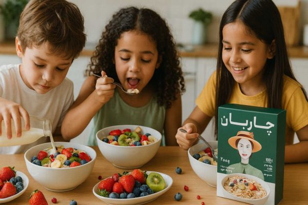 سه کودک در حال خوردن جو دوسر پرک فوری با شیر و میوه فراوان؛ جعبه محصول روی میز، نور صبحگاهی و حال‌وهوای شاد و سالم