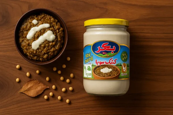 کشک سویا بکر کنار ظرف کشک بادمجان ایرانی با تزئین کشک روی میز چوبی نارون