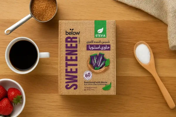 شیرین‌کننده کم کالری حاوی استویا بیلو روی میز چوبی آشپزخانه با فنجان قهوه و توت‌فرنگی تازه